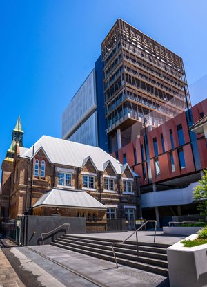 The façade of buildings at the Inner Sydney High School. One building is a brick heritage design, while the other is a modern design.