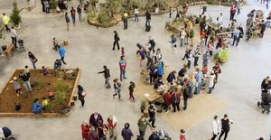 A large crowd of people attending a gardening event at the Cutaway in Barangaroo. Participants are interacting with garden beds and plants.